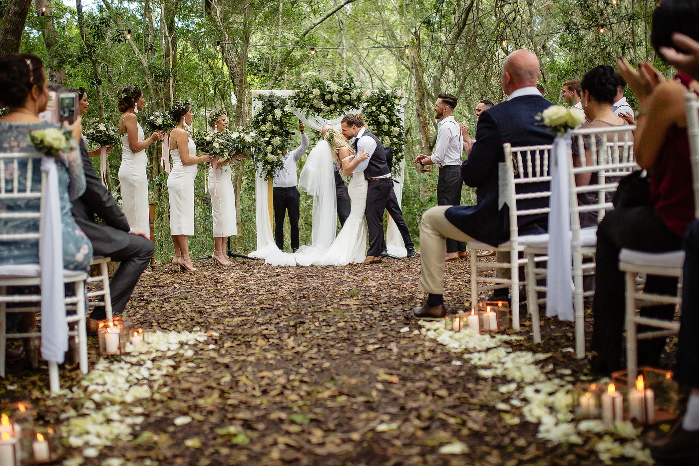 Bride and groom kiss at the altar in a forest wedding venue