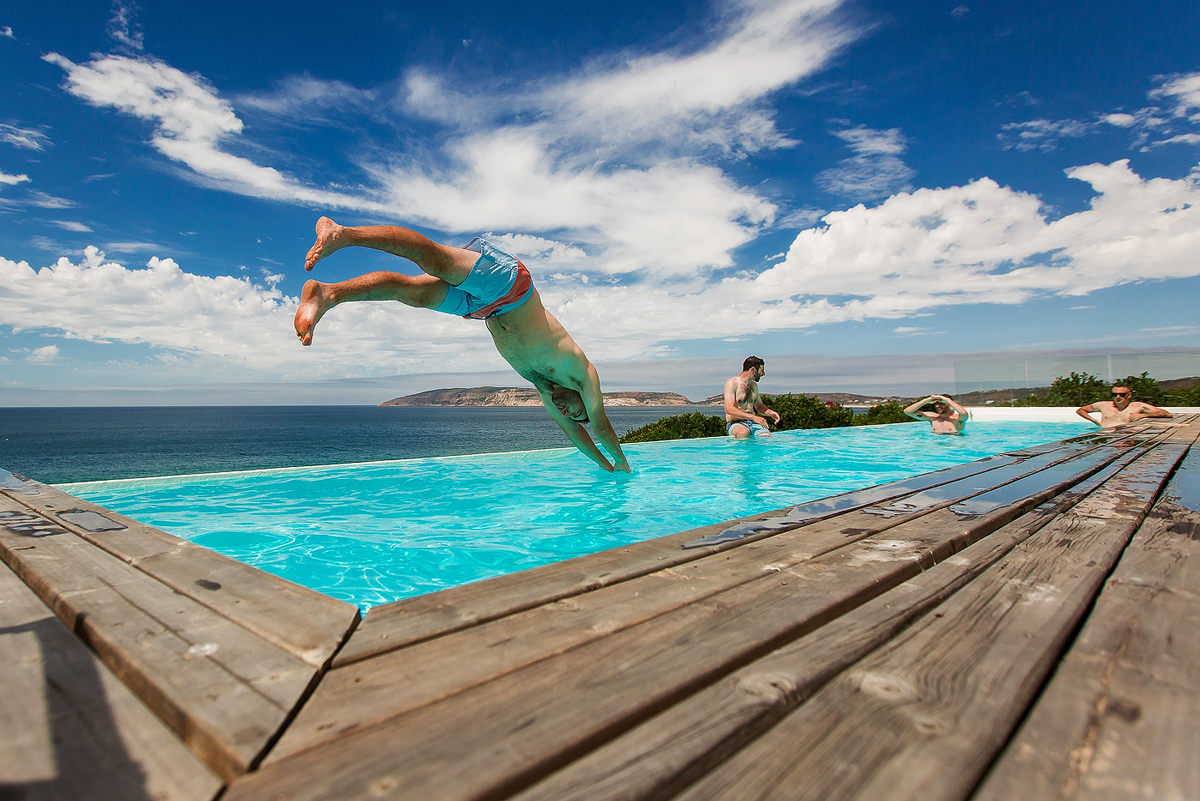 Groom jumping into swimming pool before the Jewish Wedding in Plettenberg Bay