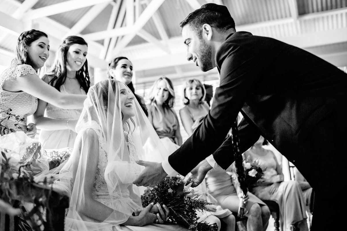 Groom putting veil on his bride at Bedeken during Jewish Wedding in Plettenberg Bay © Anina Harmse.