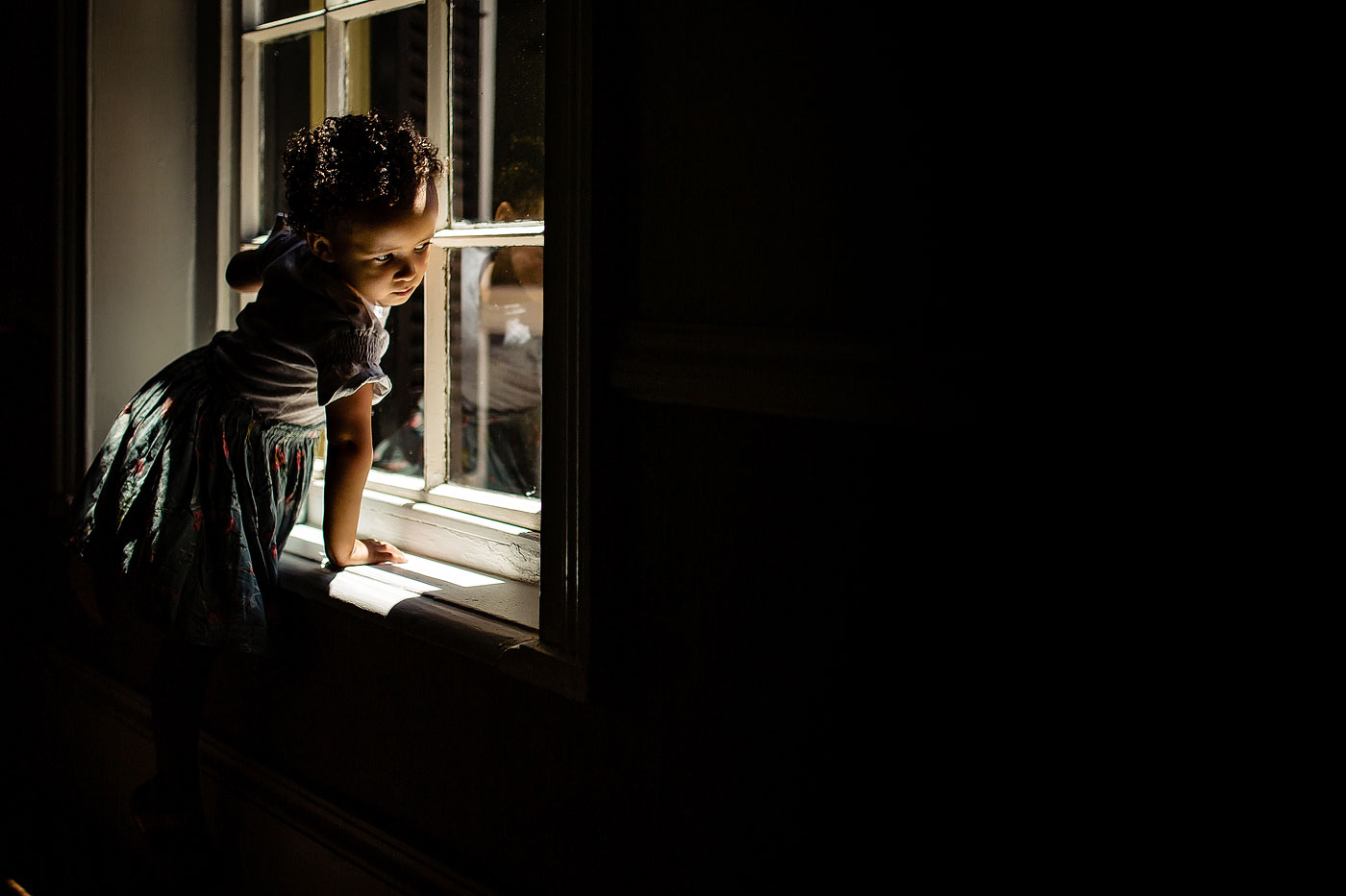 Girl looking out a window during South African wedding moment