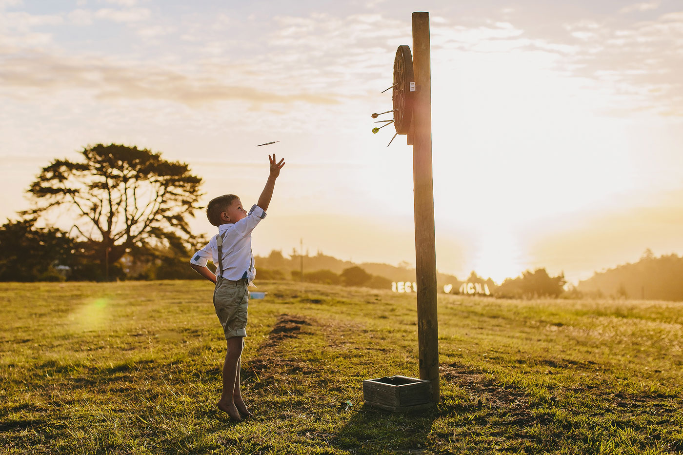 Ringbearer at a wedding in South Africa playing Darts at Sunset.