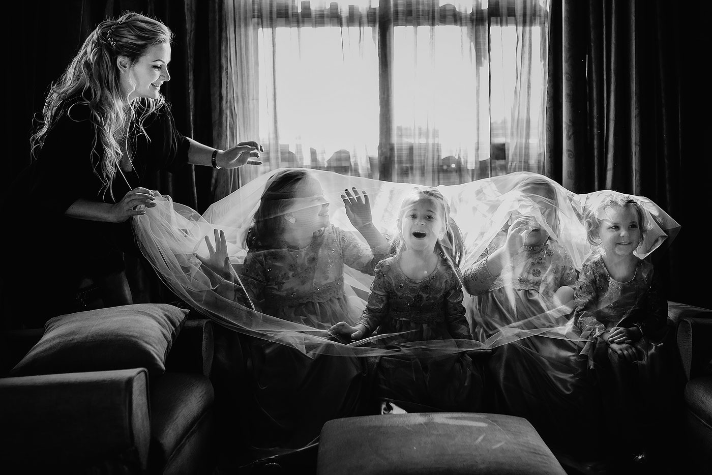 Girls at a wedding in a funny wedding moment with veil