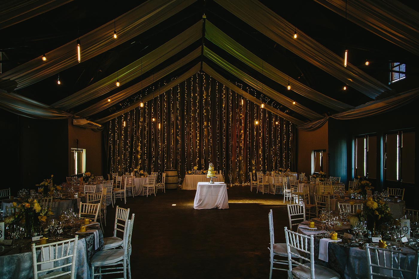 Wedding Cake with Fairy lights and decor in wedding reception area.