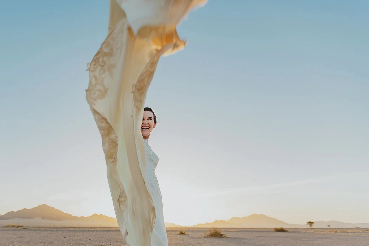 Fun and creative wedding bridal portraits with wedding dress in the Namibian desert.
