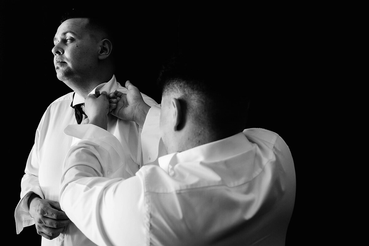Groom getting dressed in Wedding Suit with help of best man in South Africa.