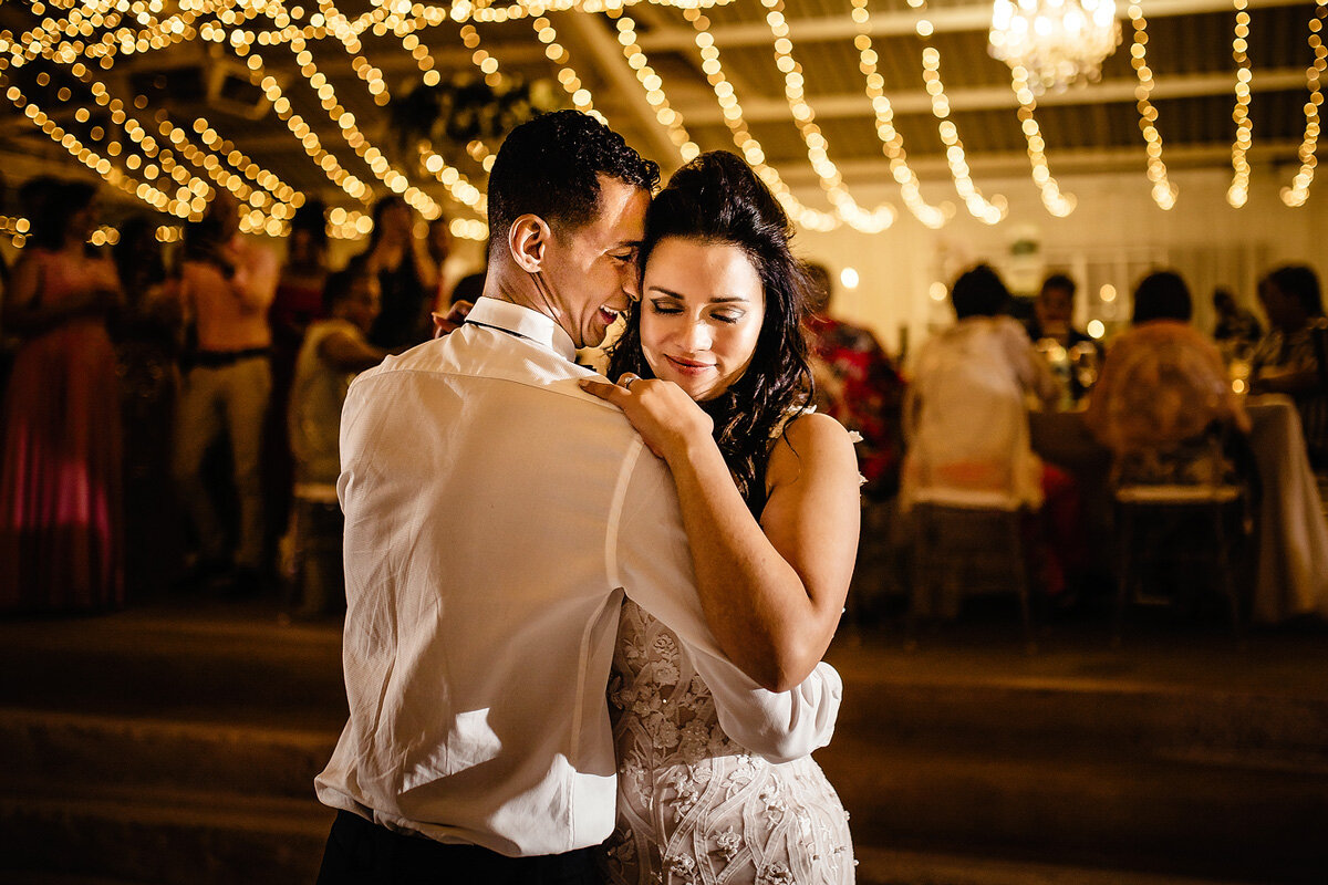 Bride and groom wedding first dance moves with fairy lights at night.