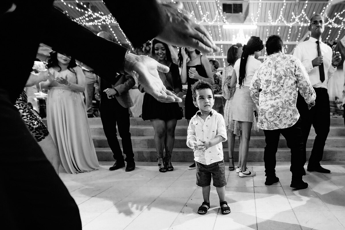 Kids at weddings on the dancefloor with father clapping in anticipation.