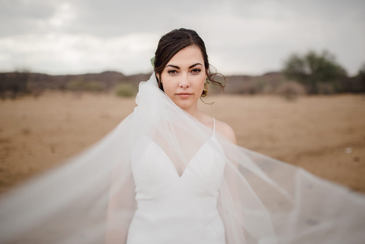 Classic creative bridal wedding portraits with bride veil in an open field in central Namibia.