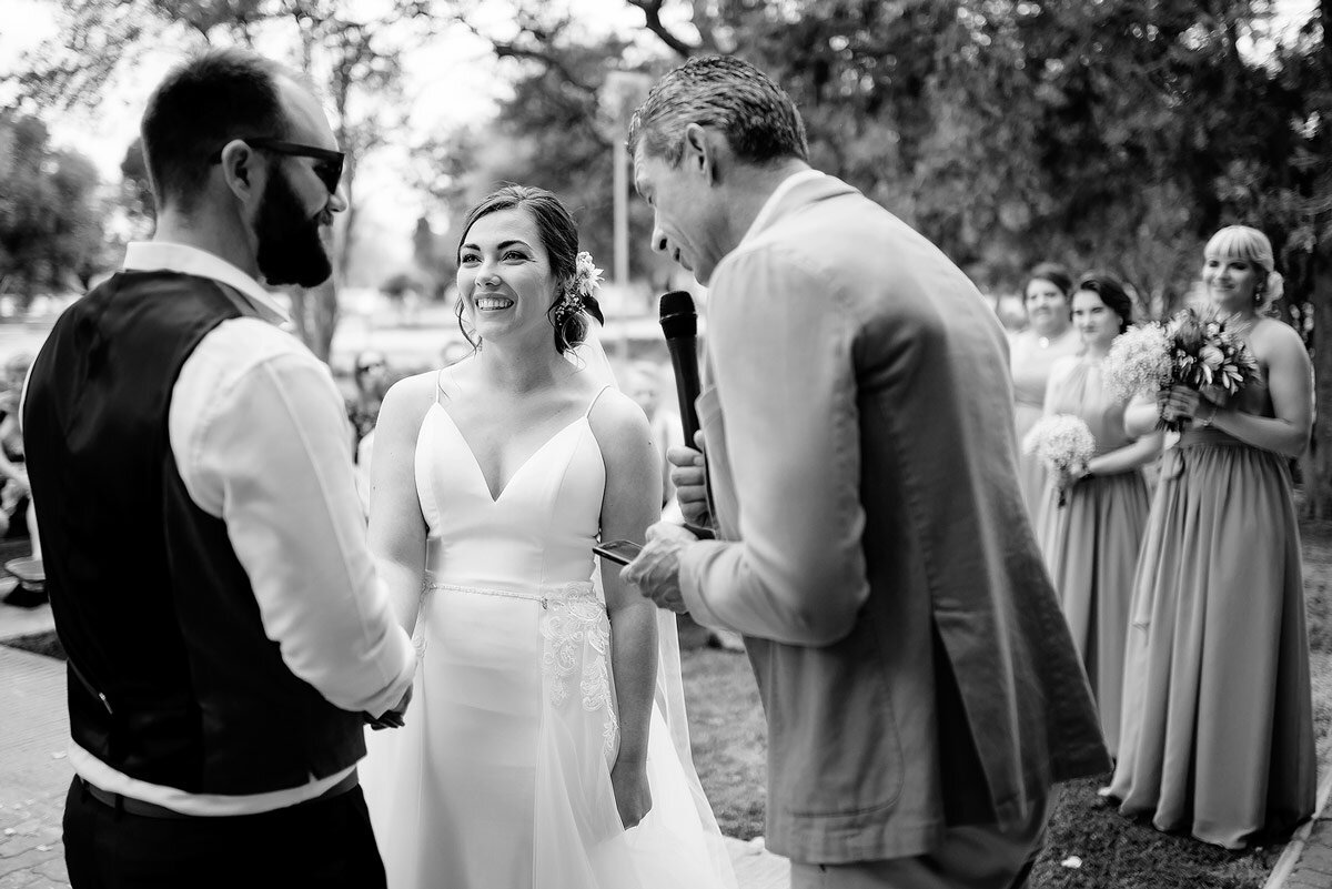 Bride and groom reacts with smiles during wedding ceremony with friends and family in Namibia.