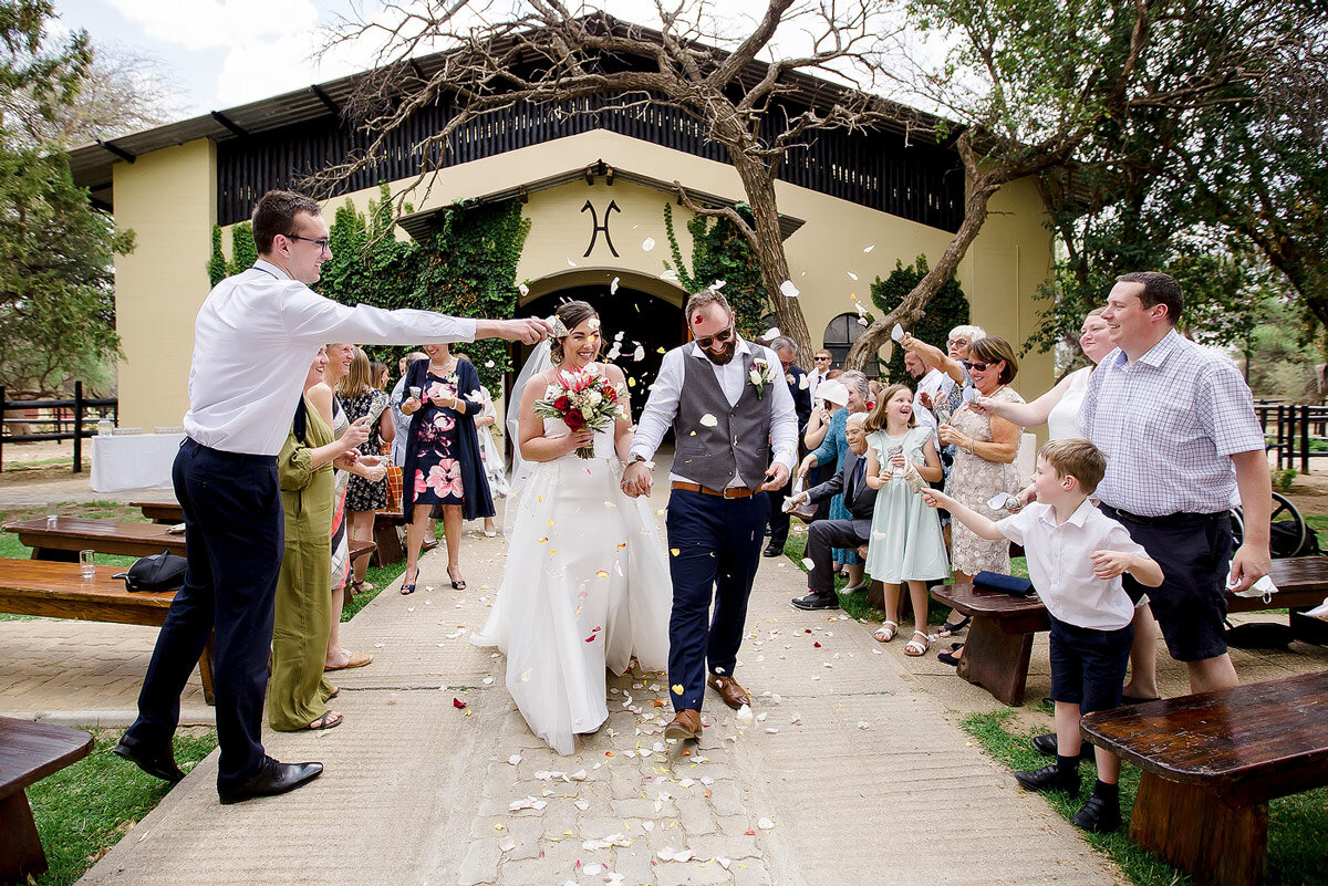 Wedding confetti of flower petals as bride and groom walks out after their destination wedding ceremony in Namibia.