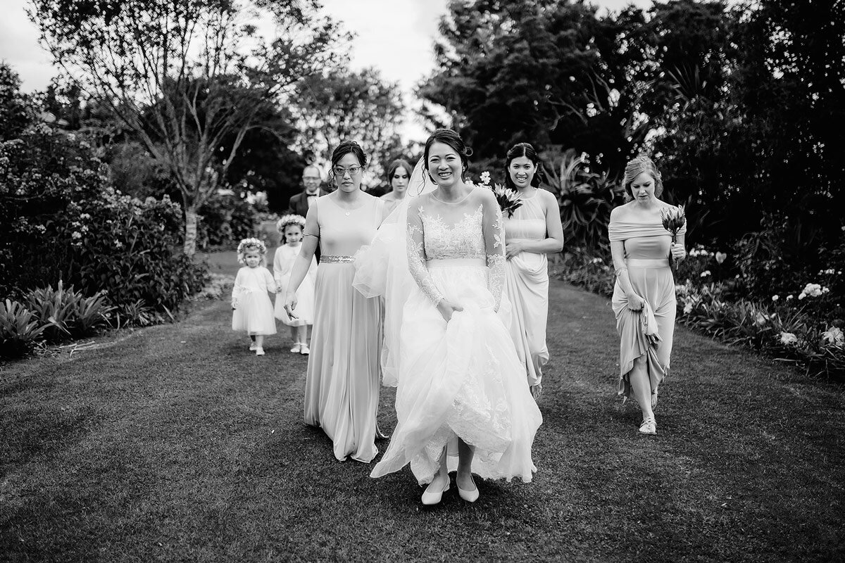 Bride and Bridesmaids with wedding flower girls walking to the wedding ceremony in a Garden near George South Africa.