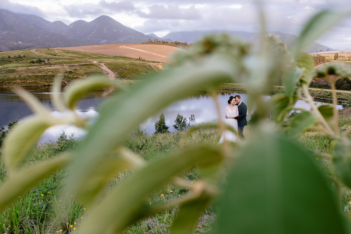 Garden Route Wedding Photographer with bride and groom and the Outeniqua Mountains in the backround.
