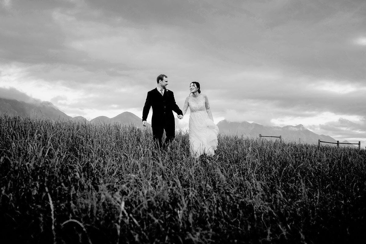 Bride and groom informal wedding portraits while walking in an open field in the Garden Route of South Africa.