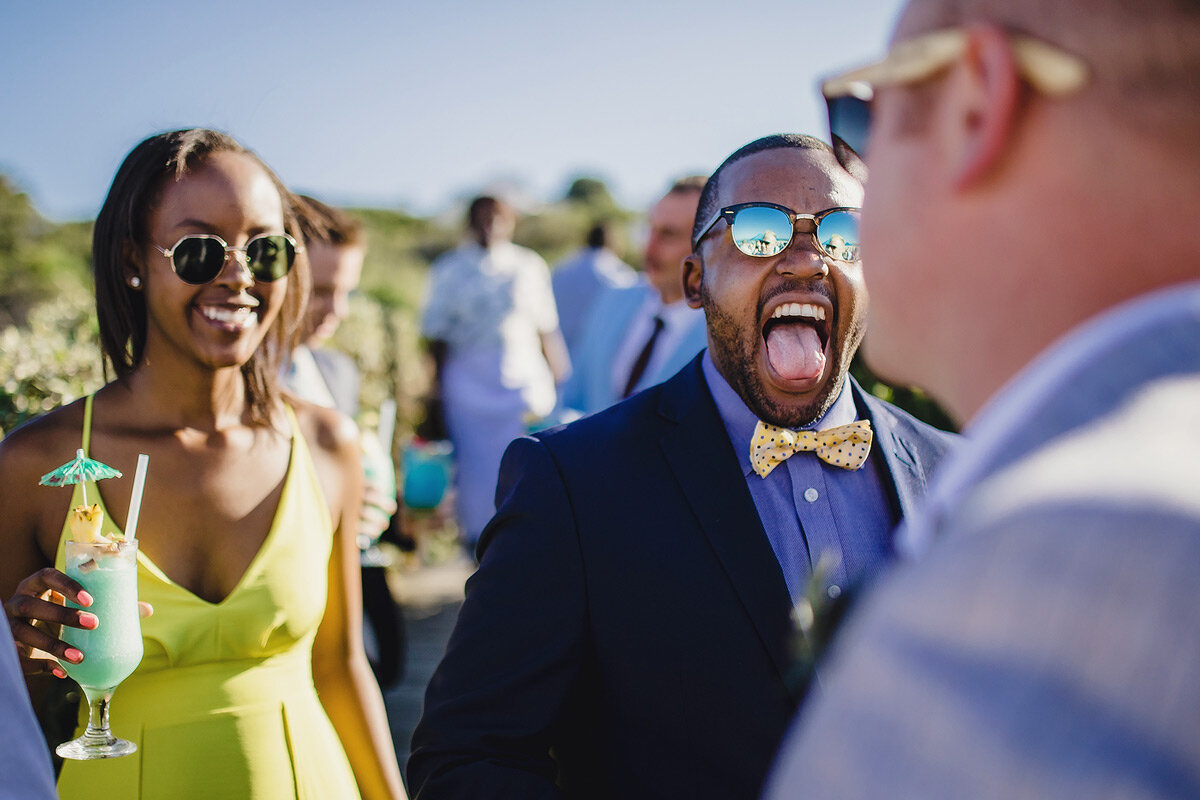 Guests react with laughter and jokes after the beach wedding ceremony.