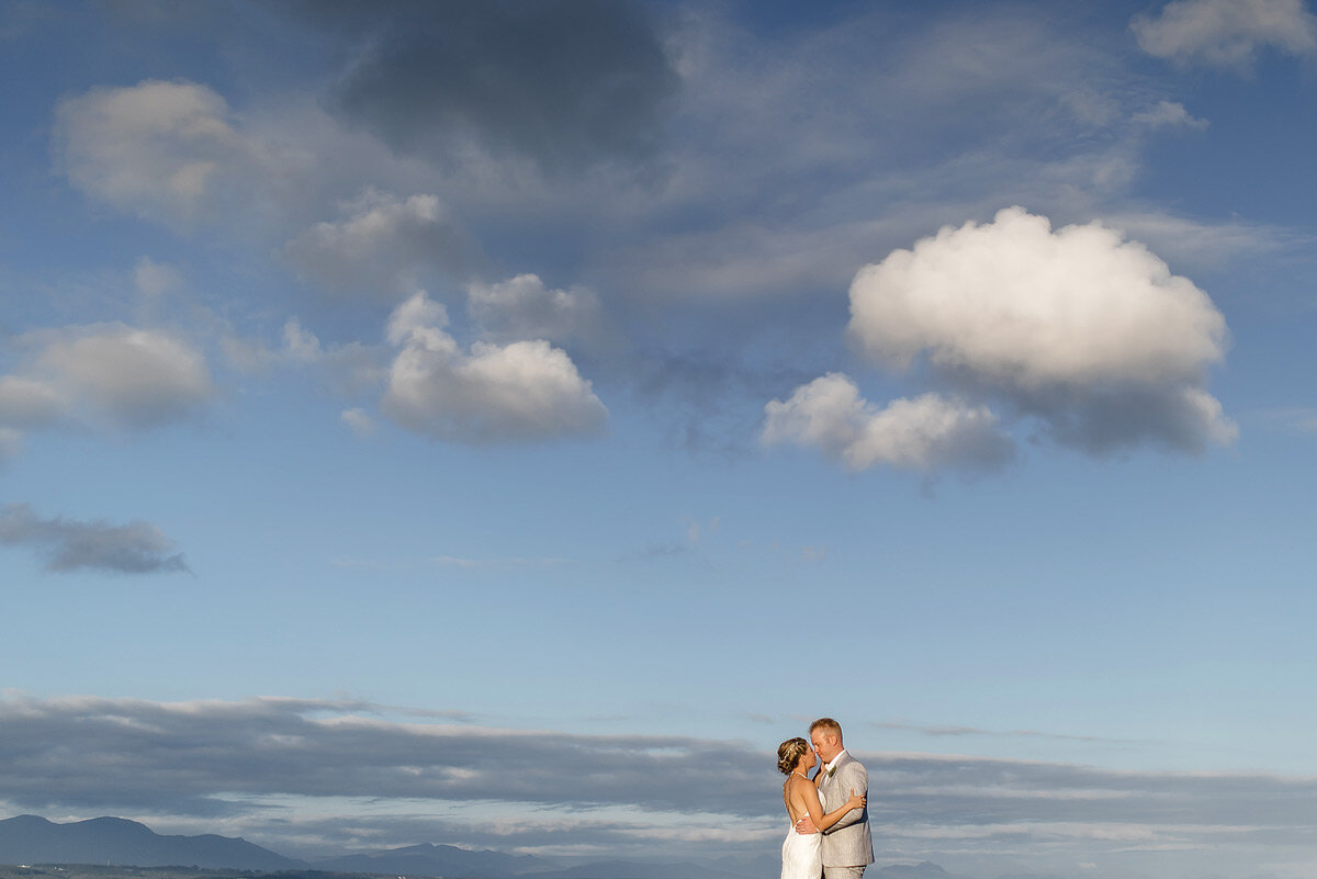 Big landscape wedding couple portraits with sunset clouds.