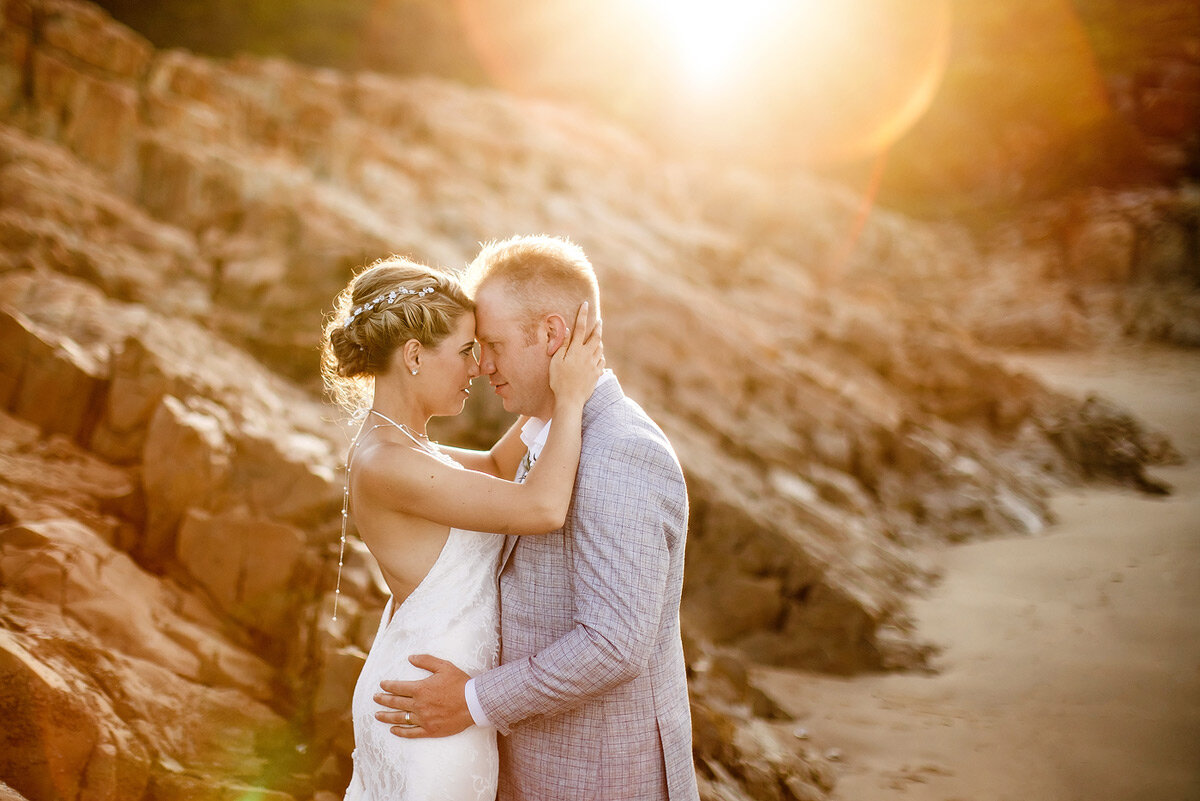 Sunset couple wedding portraits during golden hour on the beach.