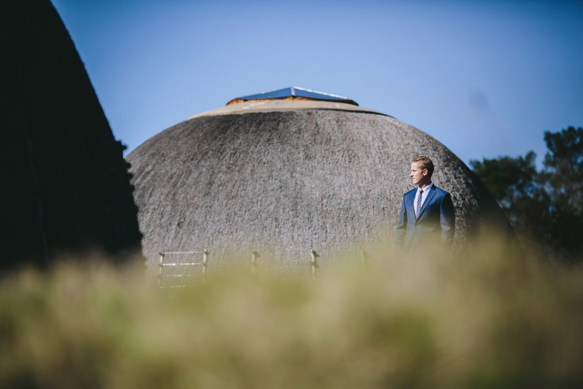 Groom Elopement portraits in front of a traditional African hut.