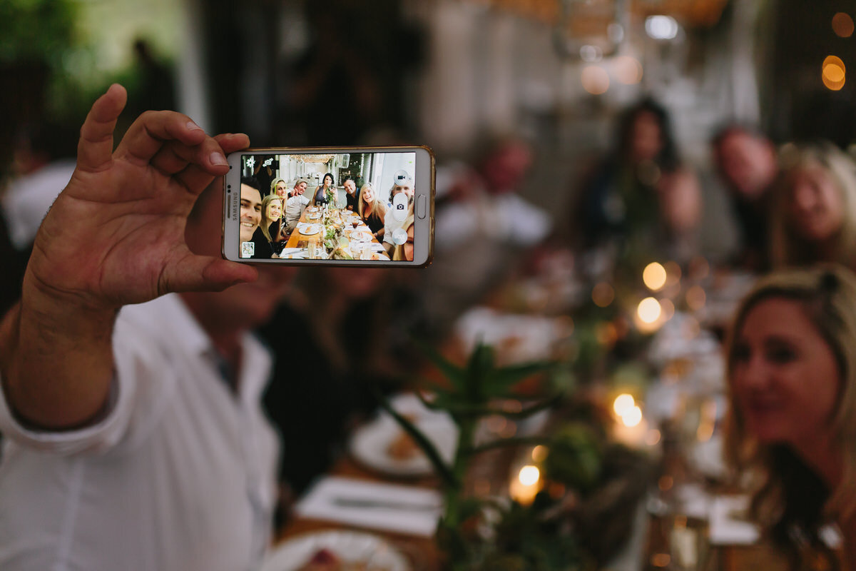 Guests taking mobile selfies at a Garden Route wedding Reception.