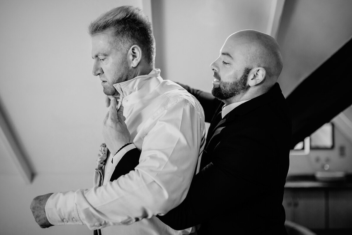 Groom being assisted with his tie during winter wedding in George.