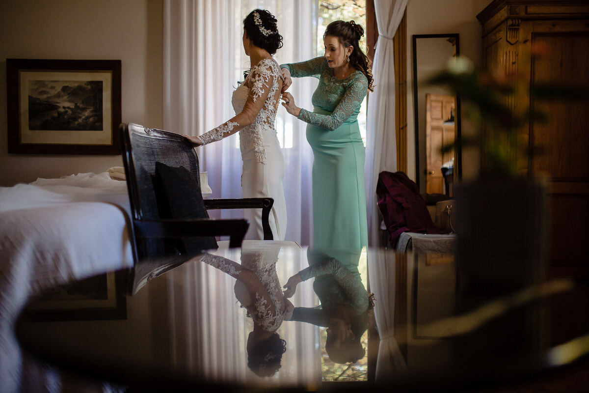Bride getting dressed in her detailed wedding dress before the garden route wedding ceremony.