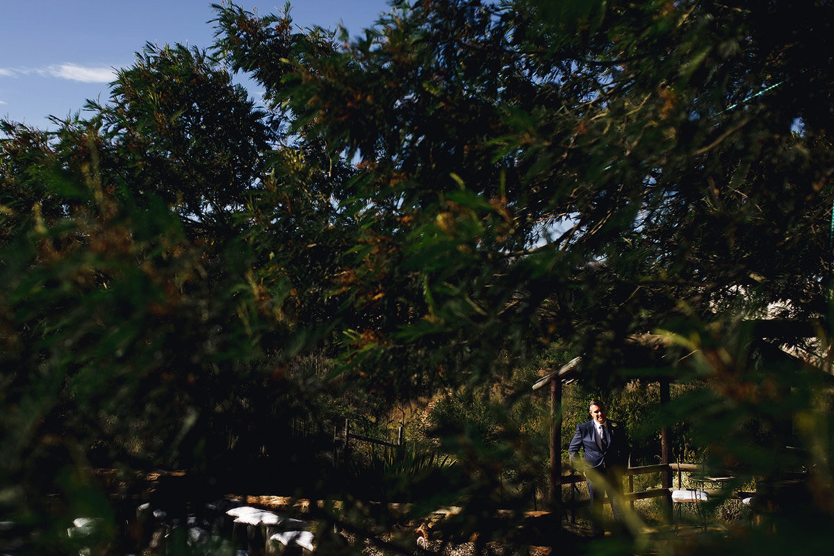 Groom waiting for his bride at an outdoor wedding ceremony venue.