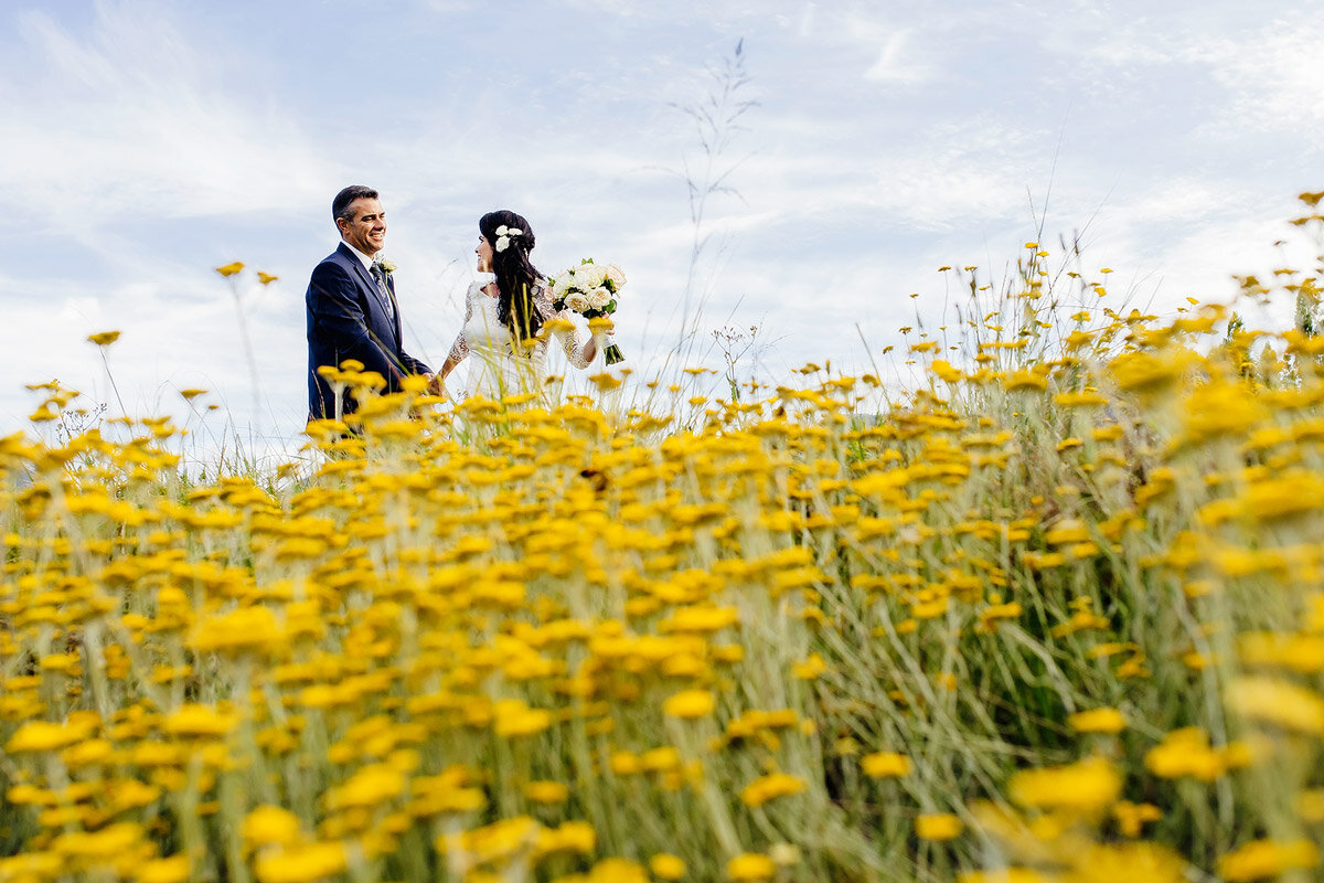 Couple portraits with yellow flowers in the foreground near George in the Western Cape.