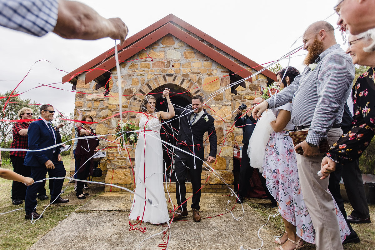 Streamer Confetti while the wedding couple walks out of the small chapel.