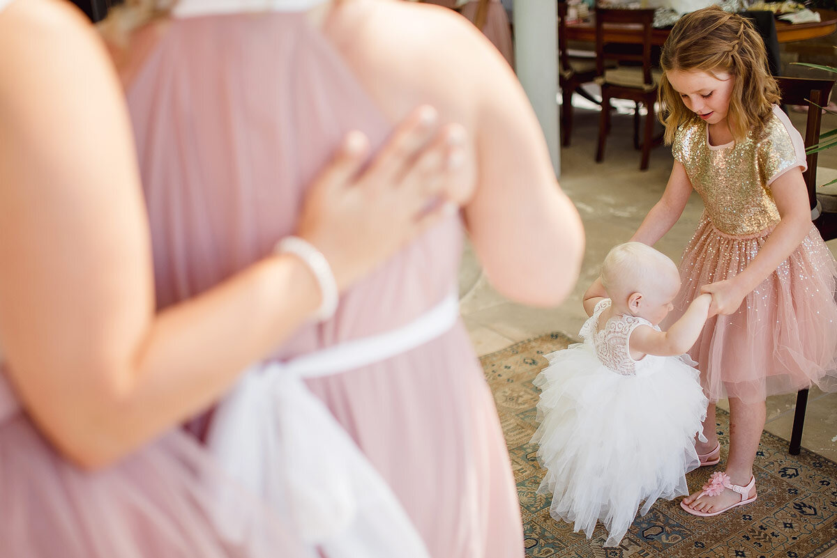 Flower girl in cute tulle wedding dress in Pastel Pink at a beach wedding.