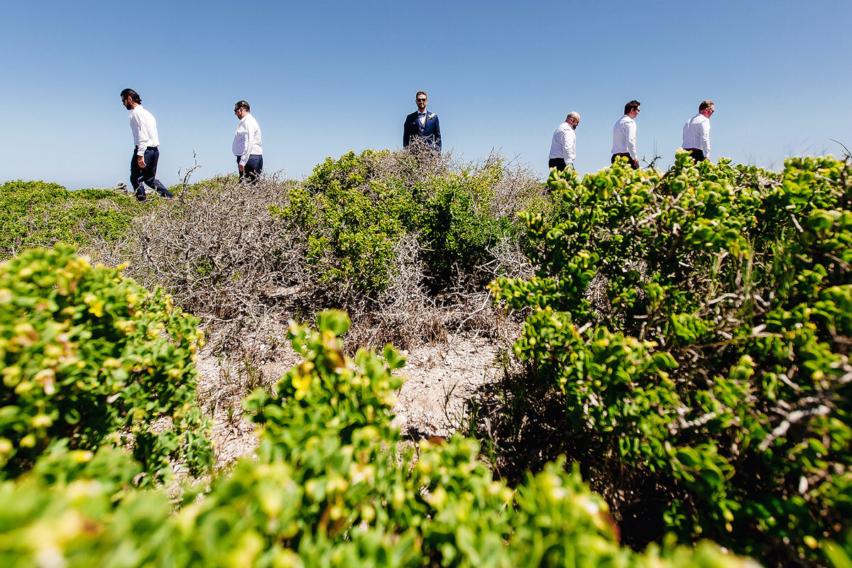 Creative Groom and groomsmen portraits at a beach wedding.