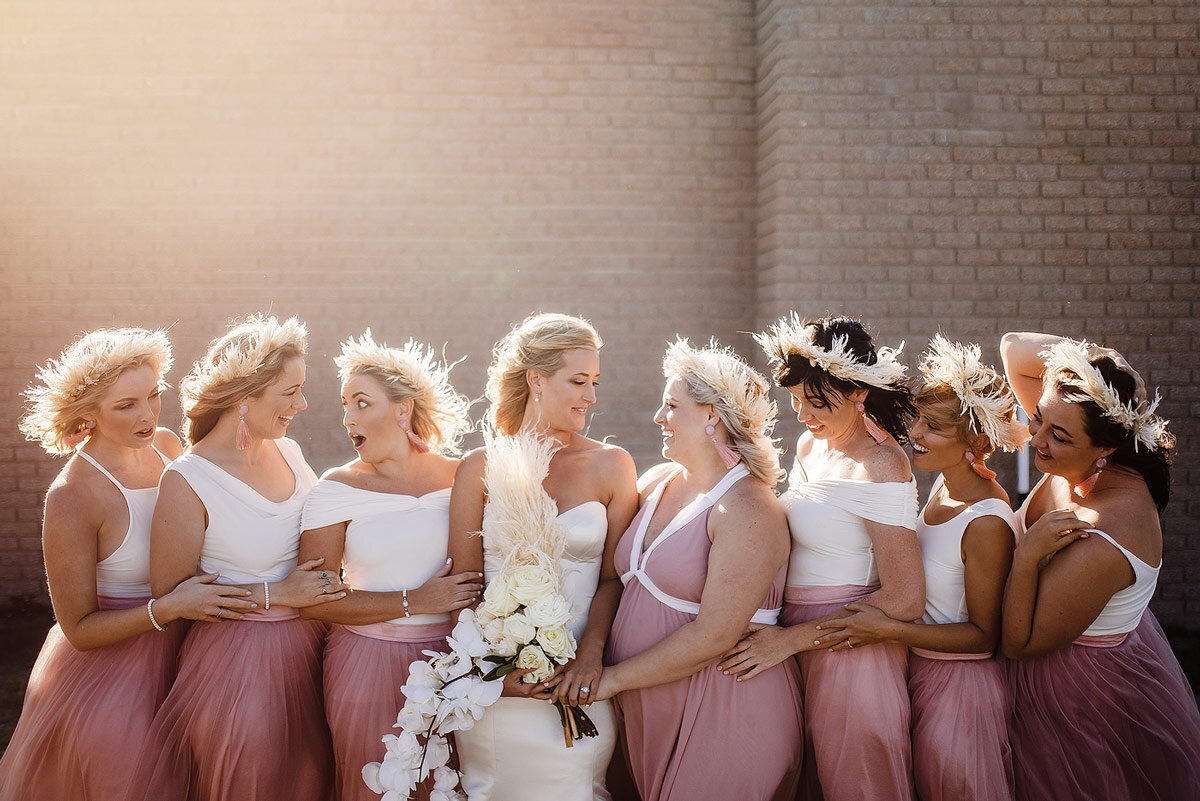 Bride and bridesmaids portraits in white and pink wedding dresses.