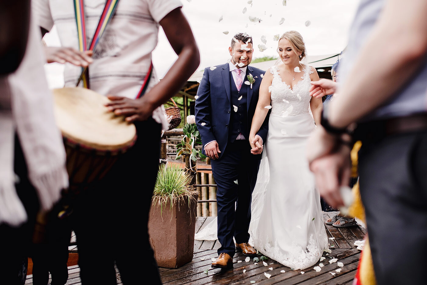 Bride and groom  walking out to flower petal confetti.