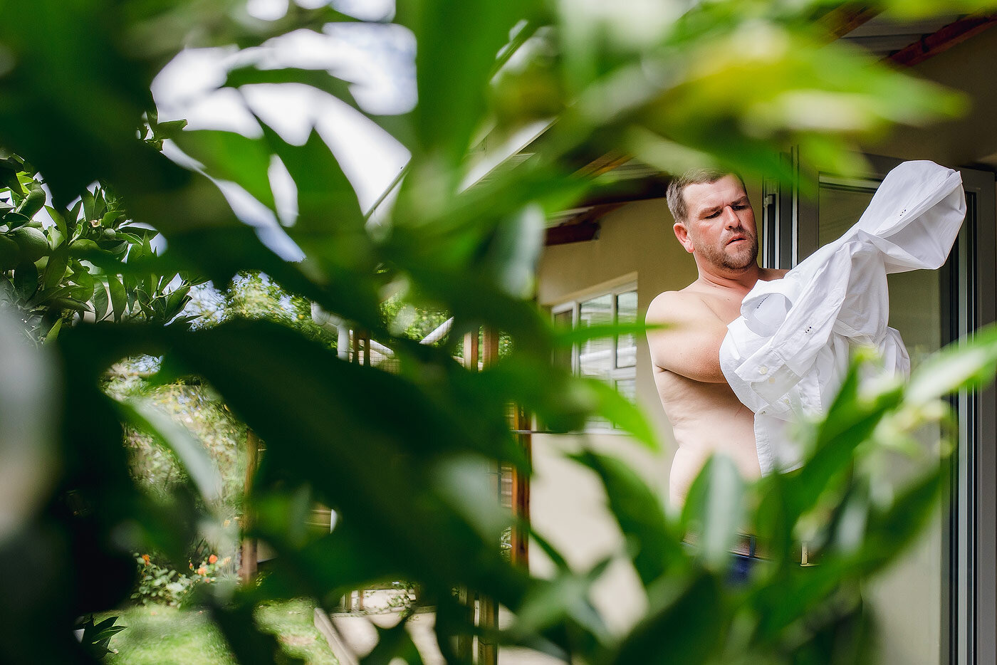 Groom getting dressed at his Garden Route accommodation.