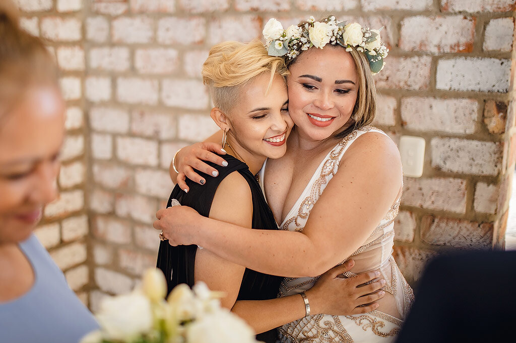 Two Brides Embrace during wedding ceremony