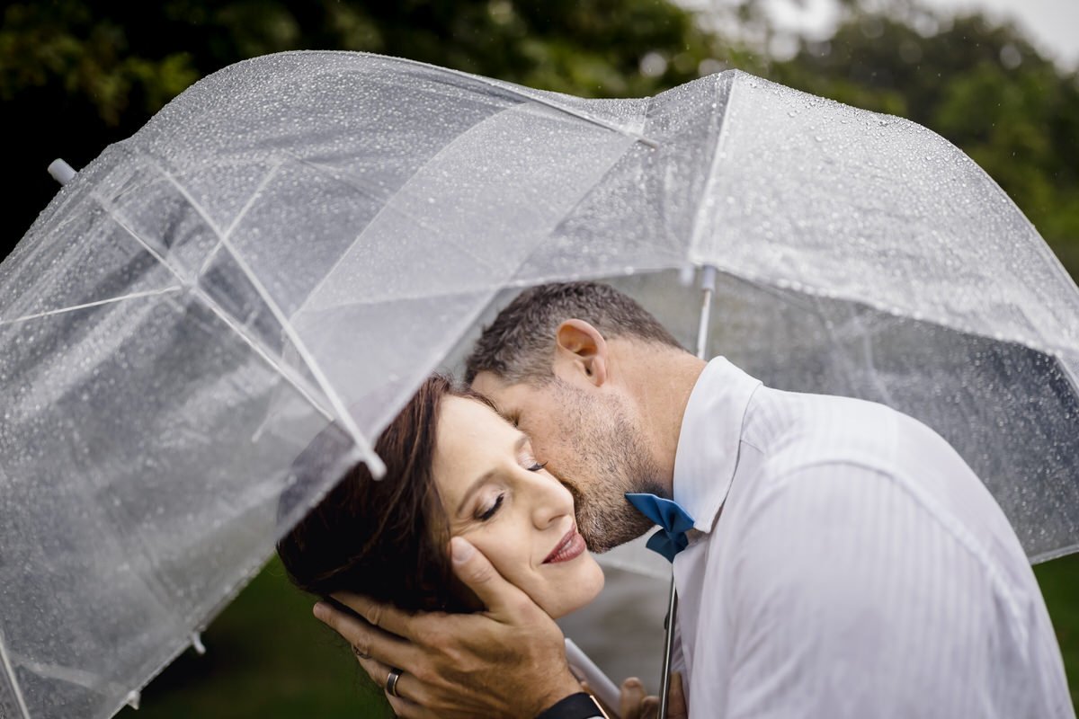  Couple under an umbrella during rain on their wedding day. 