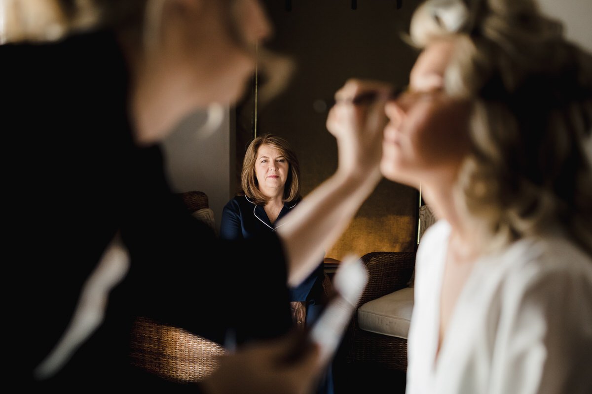  Mother of the bride in the background during bridal make-up. 