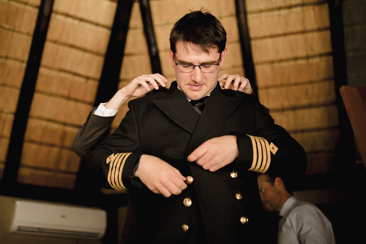 Groom putting on his service wedding suit.