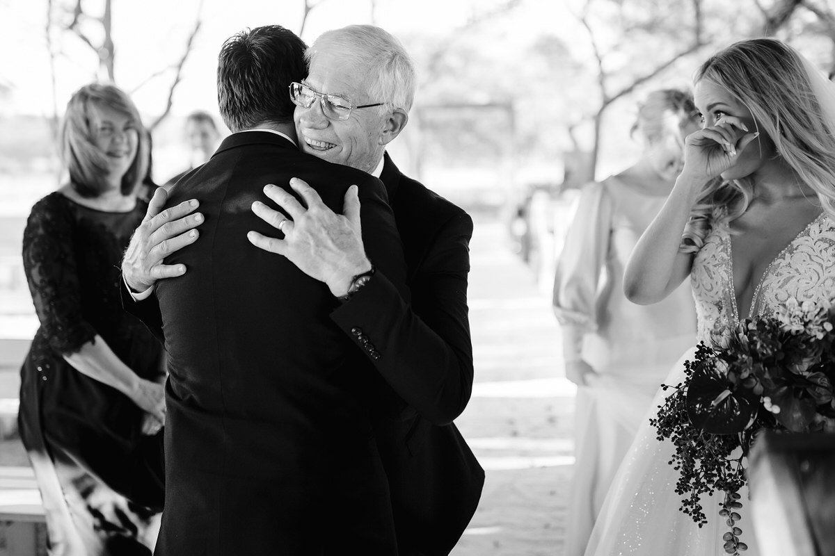 Father of the bride embrace the groom before wedding ceremony.