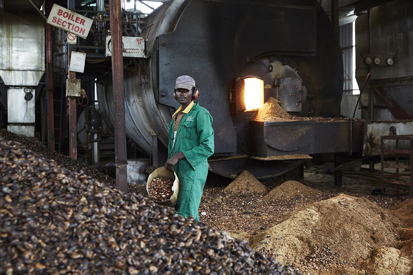 A factory worker fuels the boilers with green fuel. Makomboki Tea Factory in Kenya has taken climate change mitigation measures to reduce the amount of firewood used to fuel the boilers. It now uses cheaper greener fuel made from biomass briquettes along with sawdust and cashew and macadamia nut husks. 