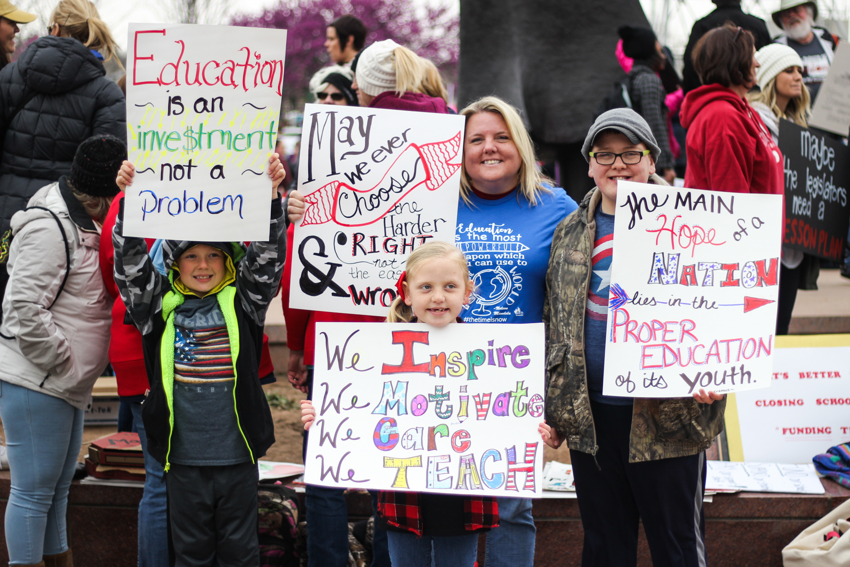 Holly Bittner and three of her children show off their signs at the walkout.