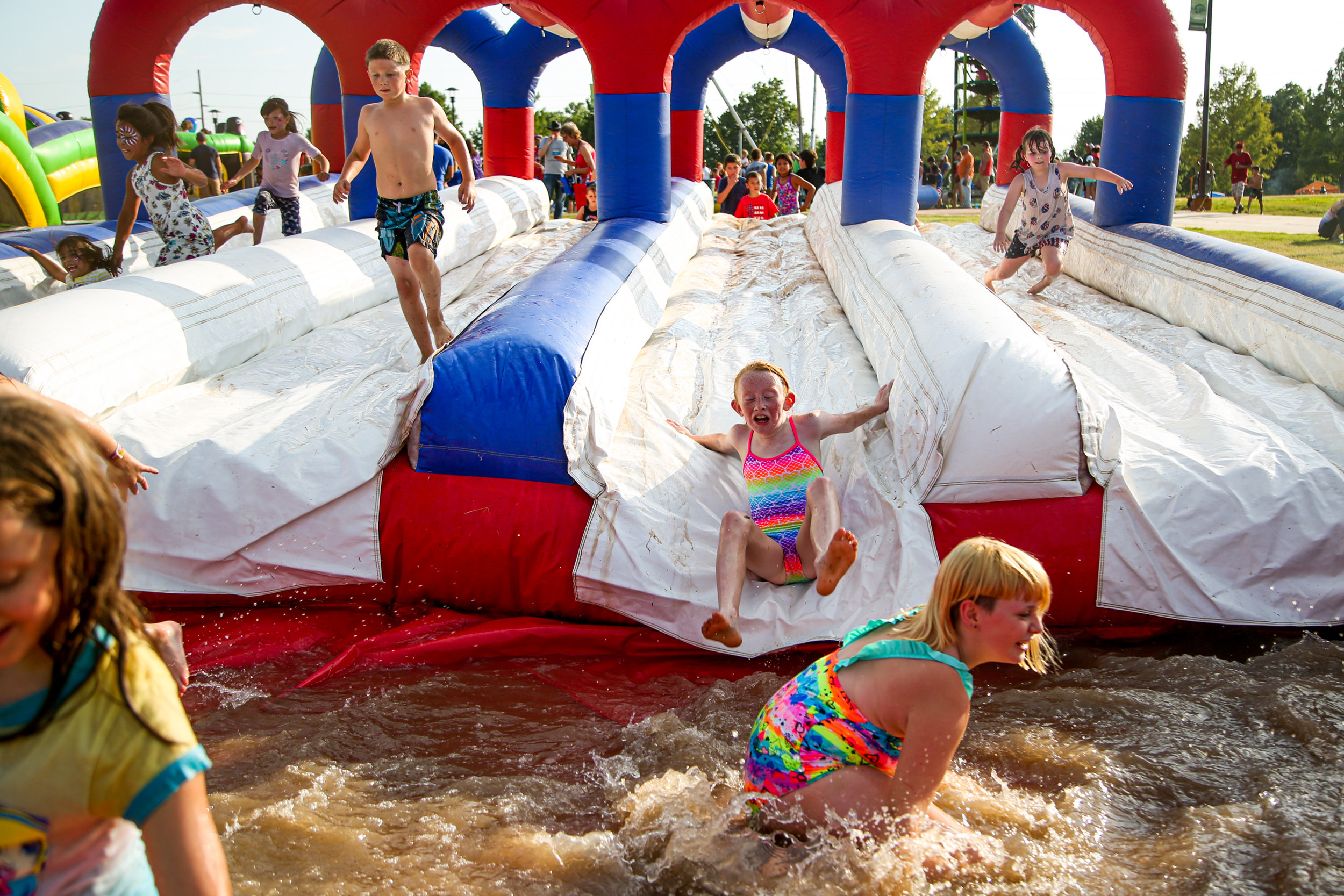 Children play on an inflatable waterslide during FreedomFest at River West Festival Park in Tulsa on July 4, 2019.