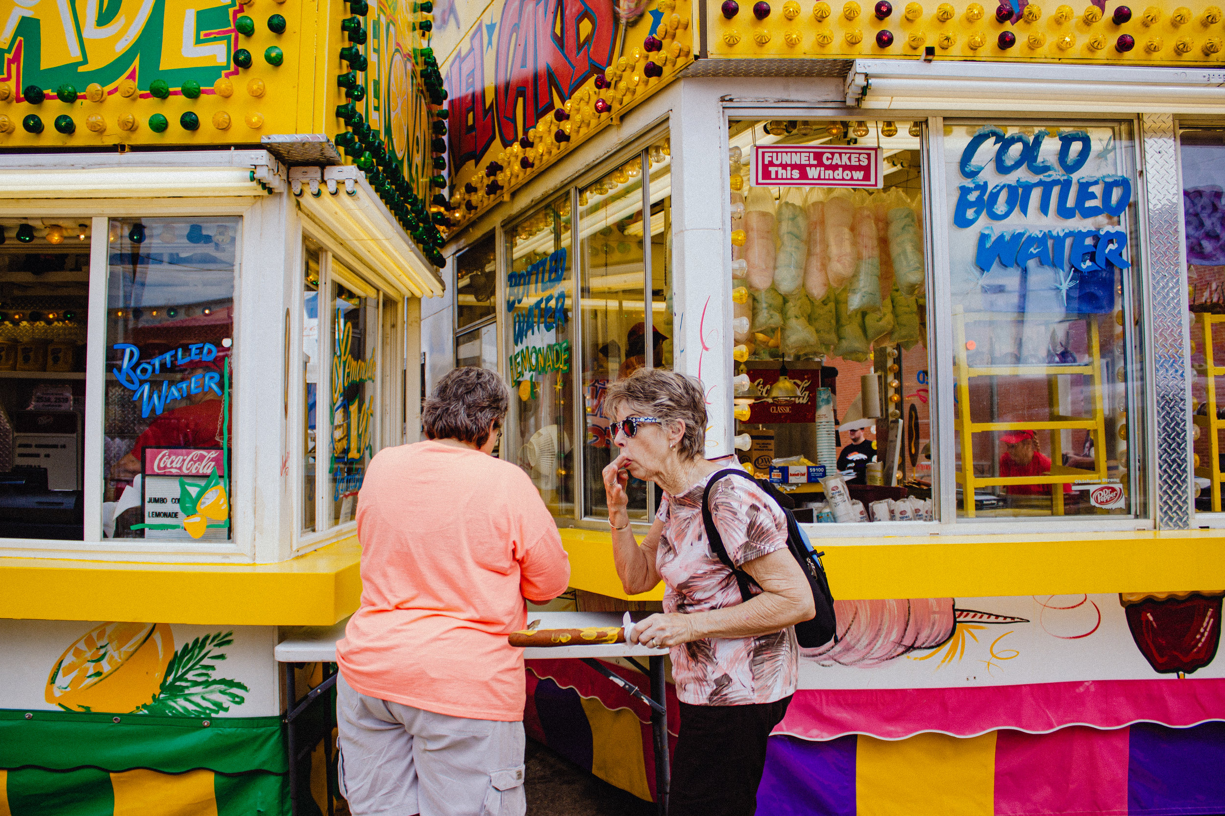 A pair of fairgoers add toppings to their corndogs on the opening day of the Oklahoma State Fair in Oklahoma City on September 14, 2016.