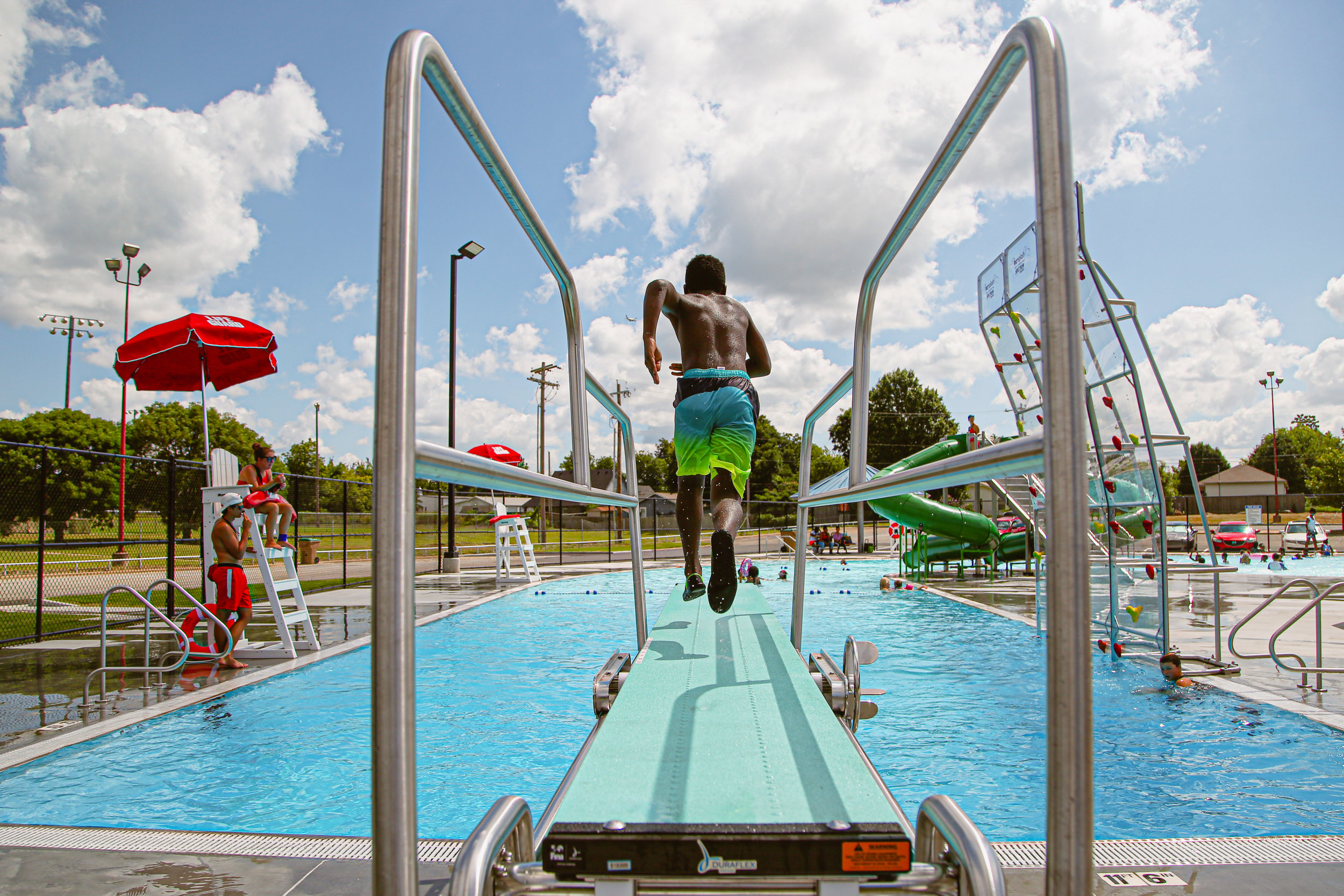Raion Hill runs off the diving board into the newly-opened pool at Lacy Park in Tulsa on July 12, 2019.