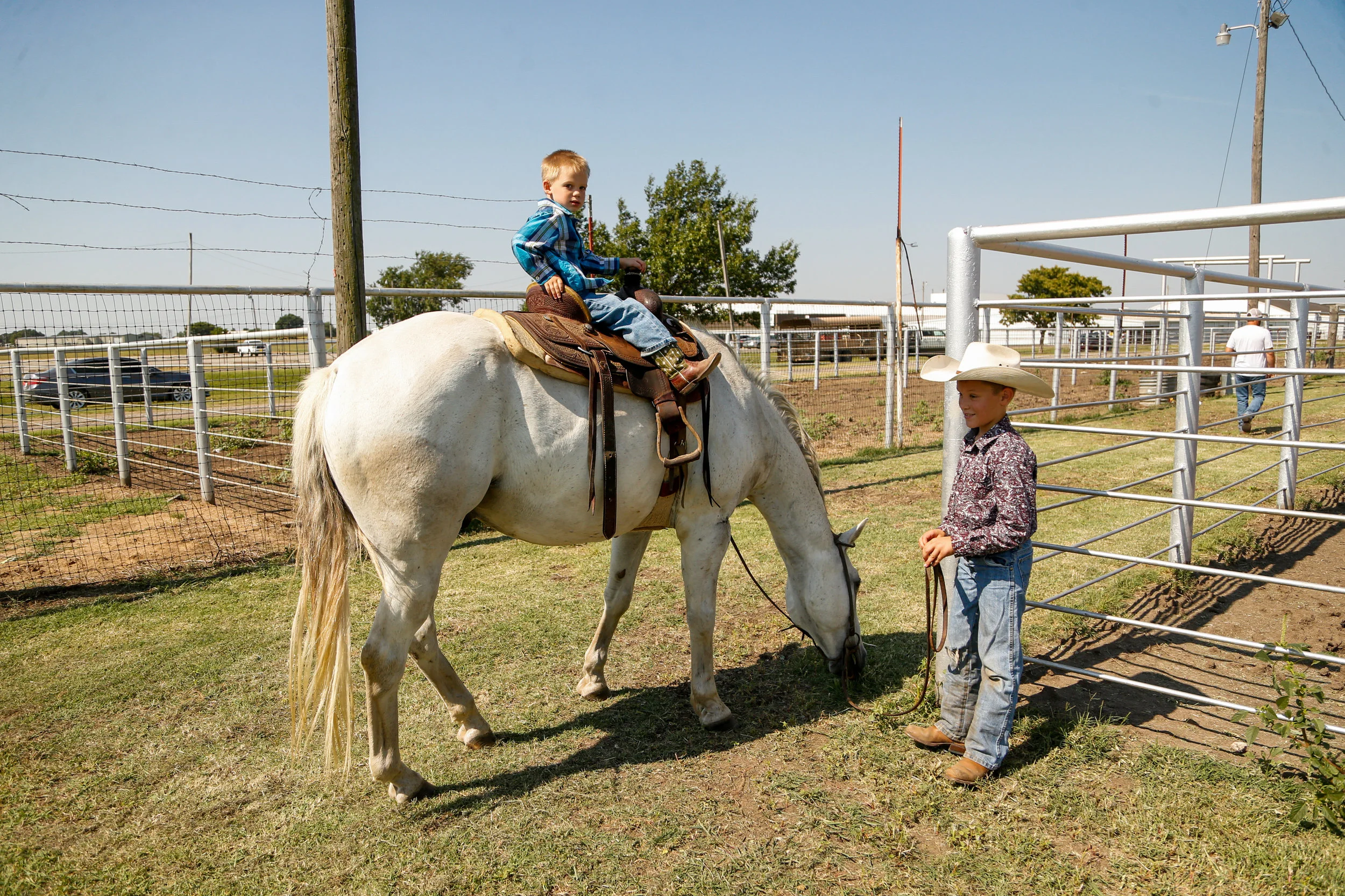 A pair of young boys walk their horse around the pens at a youth ranch rodeo at the 101 Arena in Ponca City on July 27, 2019.