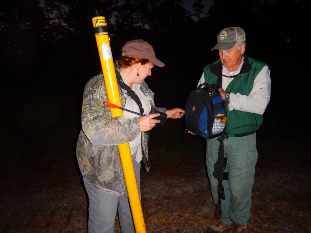 SCDNR RCW Project Leader Caroline Causey and Regional Biologist Dean Harrigal demonstrate some of the equipment used by the biologists who study the birds. "Peeper cams" on extendable poles allow them to look into a nest cavity to check on the birds, and the resulting images or video can be captured and transmitted to a laptop computer on the ground.