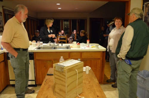 SCDNR biologists Derrell Shipes, Caroline Causey and Dean Harrigal talk with members of an RCW translocation team made up of staff and volunteers from several state and federal agencies at Donnelley lodge. In the foreground is an example of the box that is used to transport the birds to their new home.