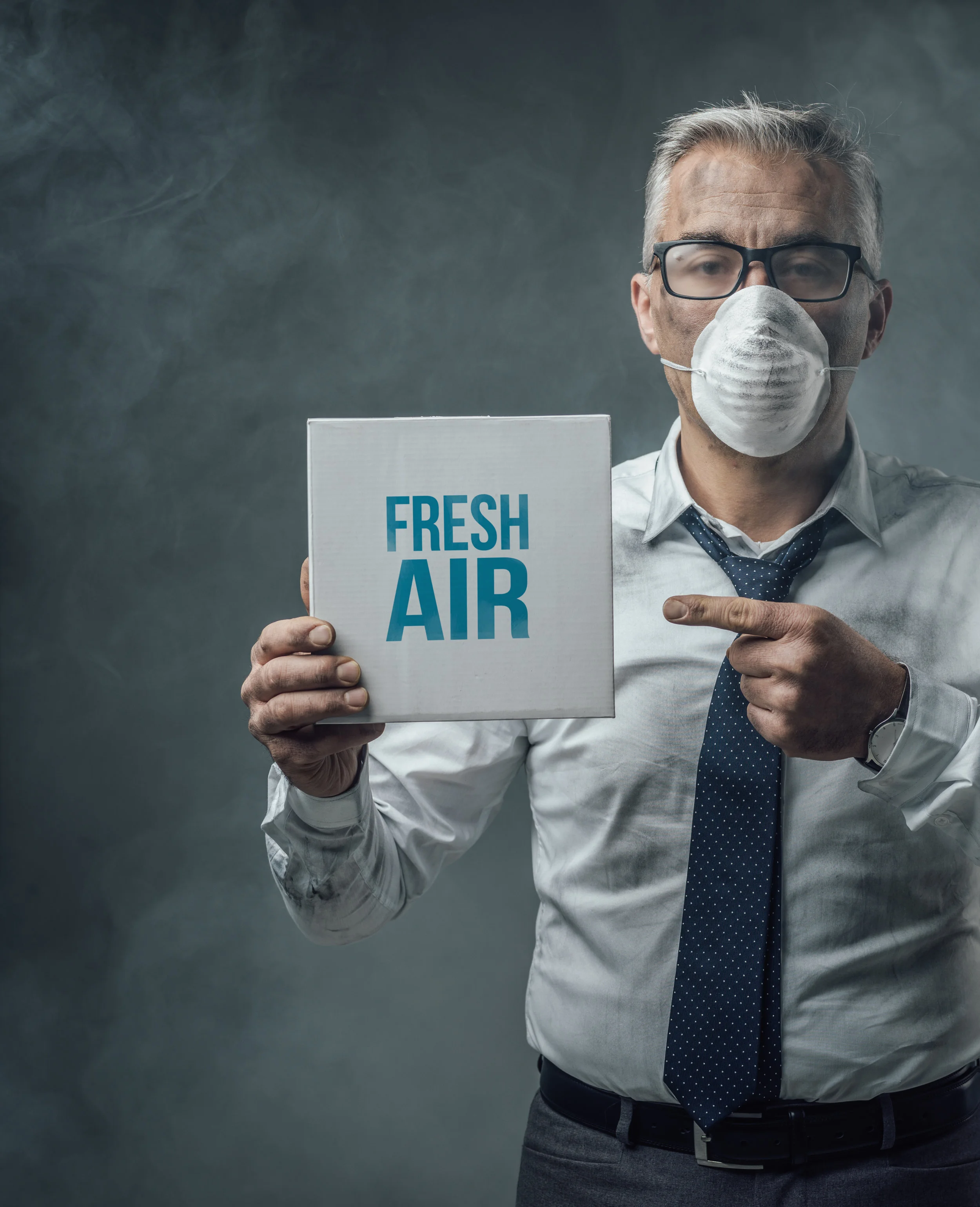 businessman-holding-a-sign-and-air-pollution-PCD58LL.jpg