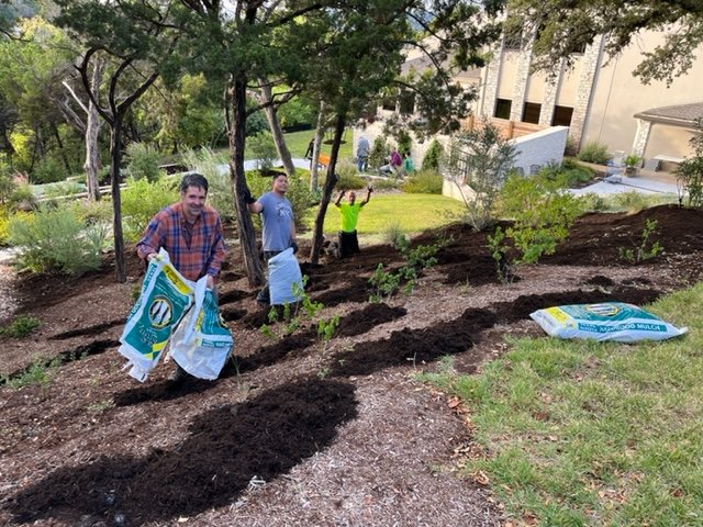 Kevin, Samuel, and Dave Evans mulch the high gardens 