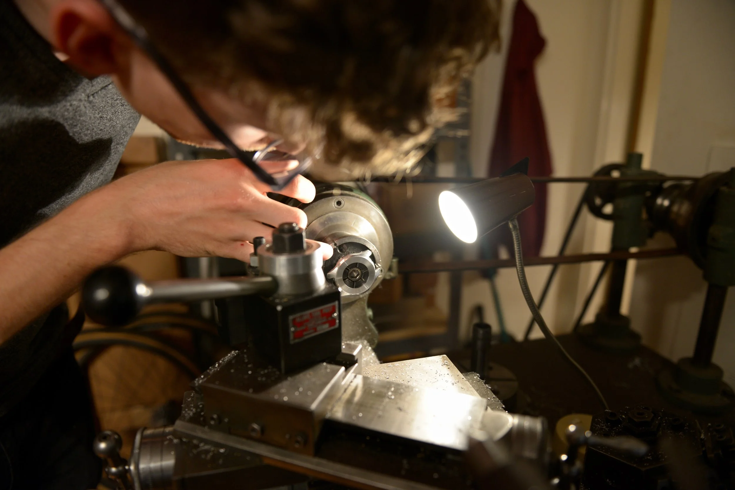 Ian, inspecting his watch case after a round (geddit? It spins!) on the lathe.