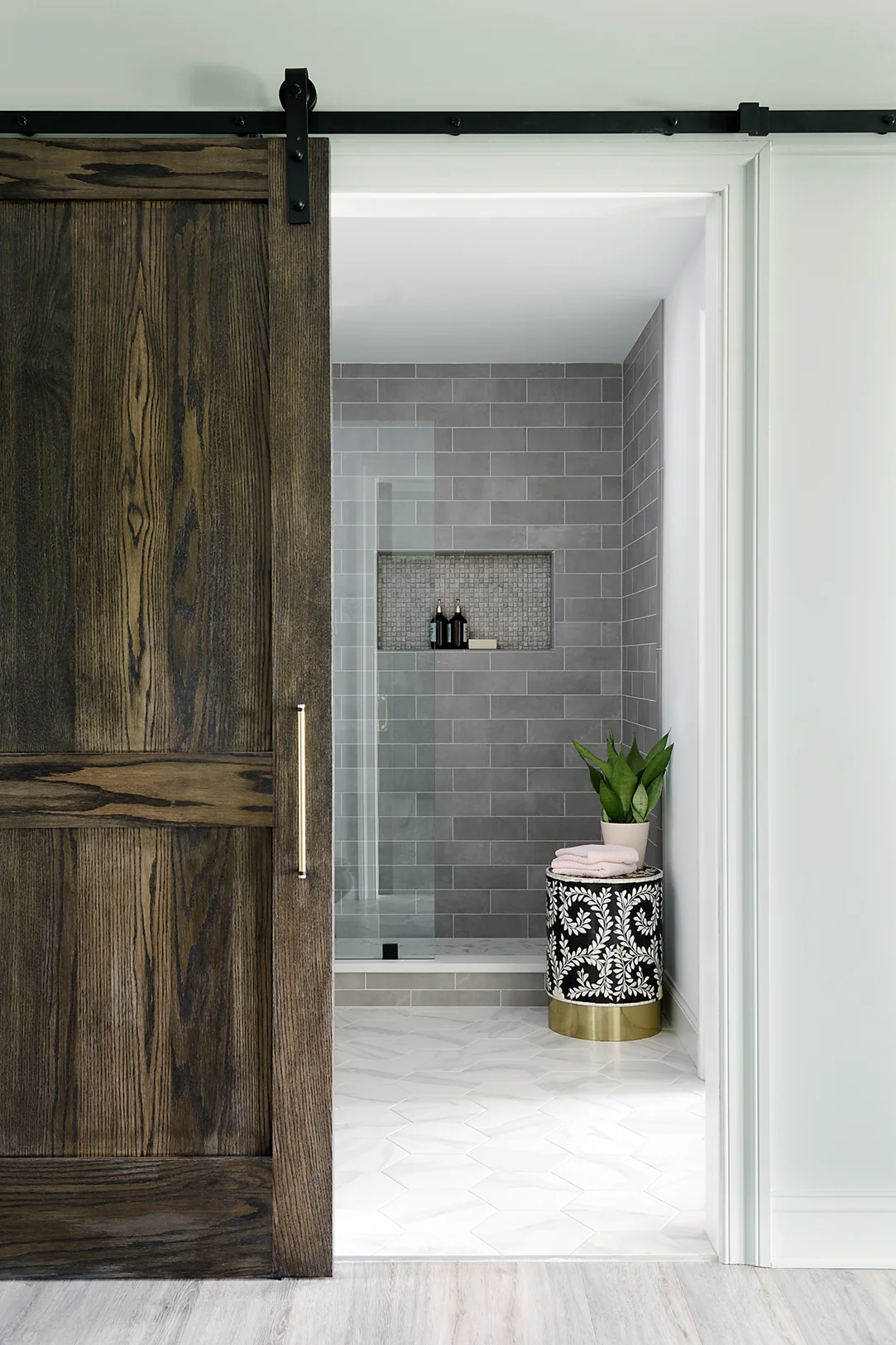The sliding barn door adds the perfect final touch for this easy to access, modern bathroom. And check out that inlay stool that adds a pretty pattern to the space.