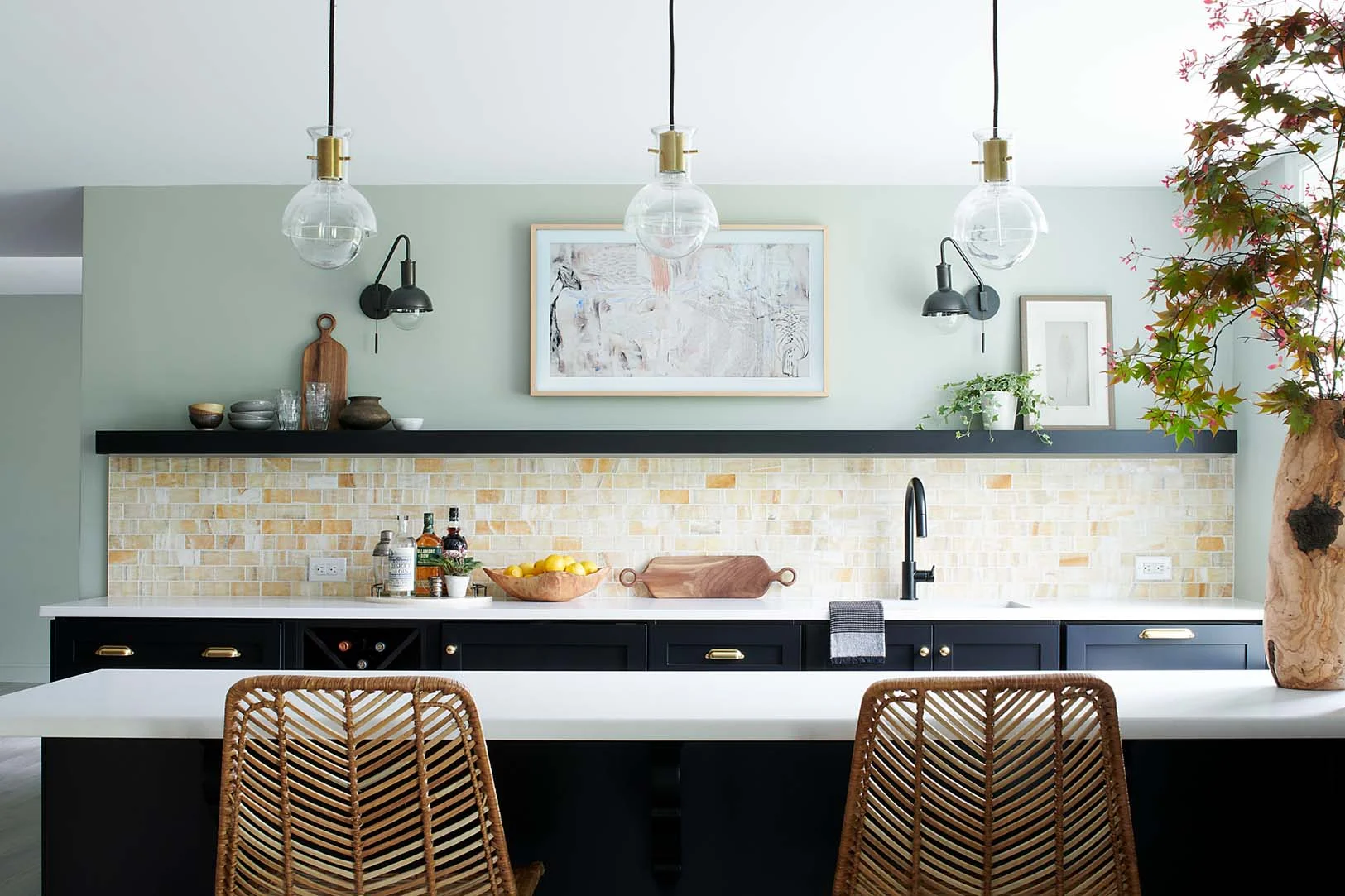 This charming space feels modern and luxe but also super warm and inviting. We love the contrast of the dark cabinetry which highlight the warm tones in the space, long with touches of green plants and wood accessories.